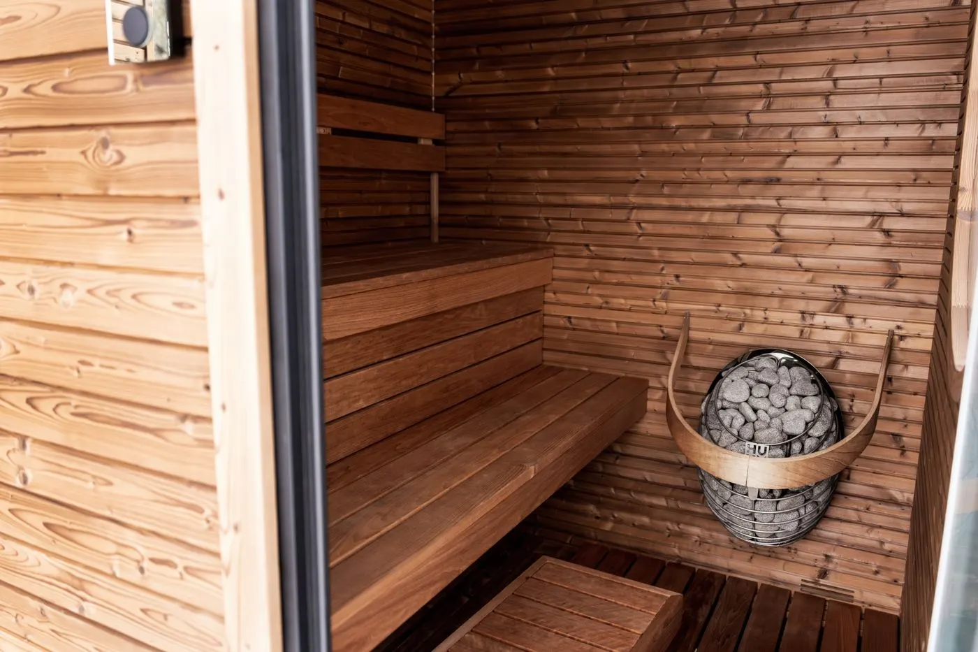A traditional wooden sauna interior with a stone heater