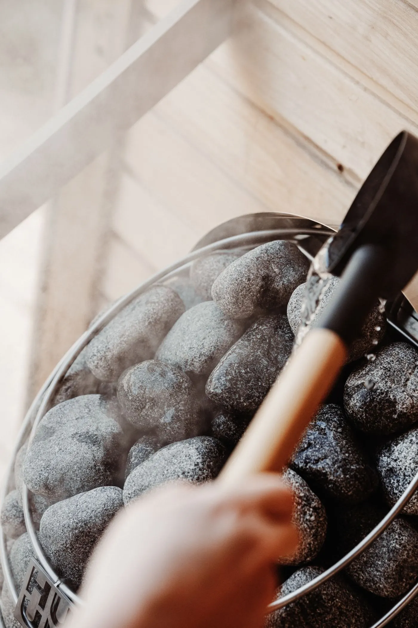 Sauna heater stones with a wooden scoop