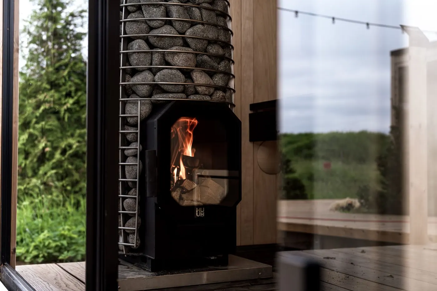 A wood-burning sauna stove beside a window